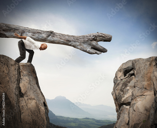 Man carries a trunk in a crevice between two mountains