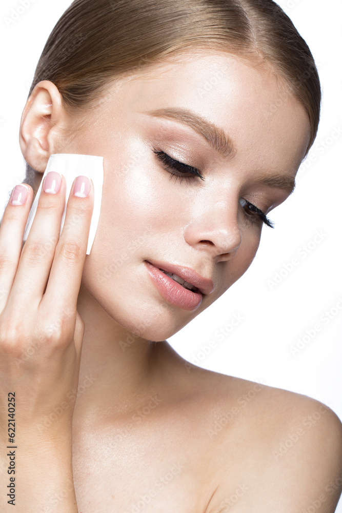 Beautiful young girl with wipes for removing makeup and French manicure. Beauty face. Picture taken in the studio on a white background.