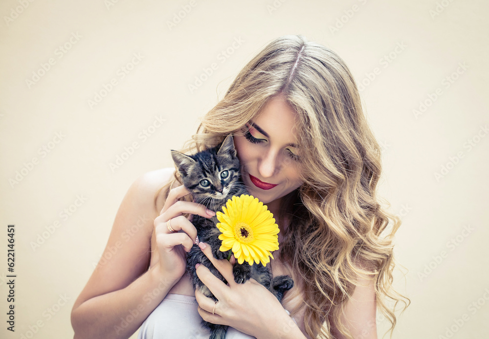Beautiful girl with a nice flower and cat in hands