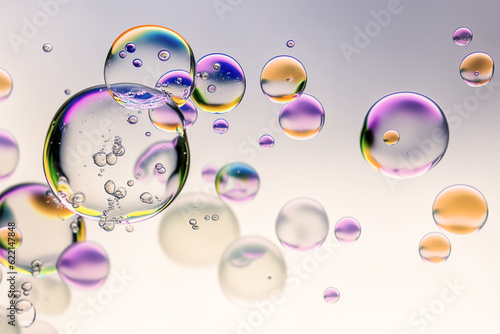 Transparent bubbles drops of gel, serum, collagen, oil, close-up, macro. Abstract neon purple background with bubbles