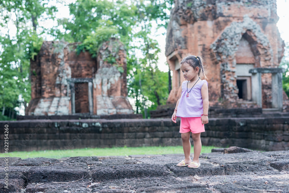 A young Southeast Asian girl walks to study the history of the ancient Khmer castle Khu Suan Taeng in Thailand, Buriram. A young Southeast Asian girl walks to study the history of the ancient Khmer castle Khu Suan Taeng in Thailand, Buriram.