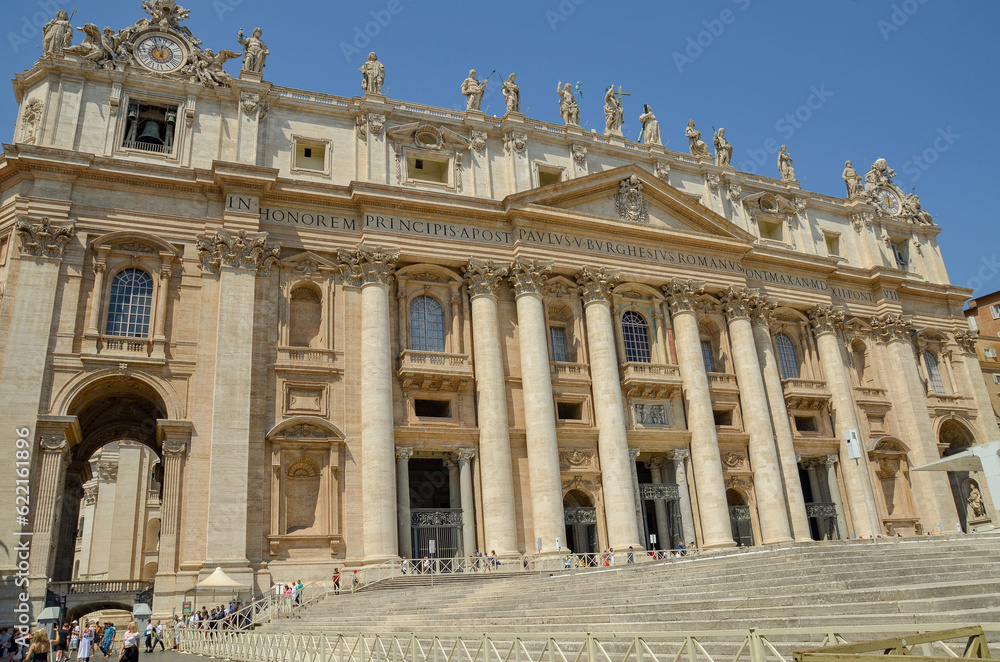  View of Saint Peter's Basilica exterior facade with sculptures, obelisk and dome.