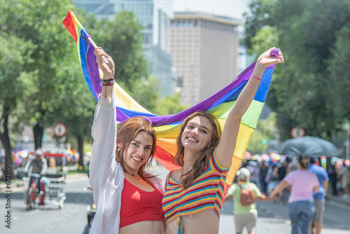 Caucasian pretty women holding a gay flag.