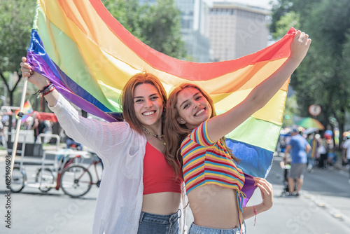 Caucasian pretty women holding a gay flag.