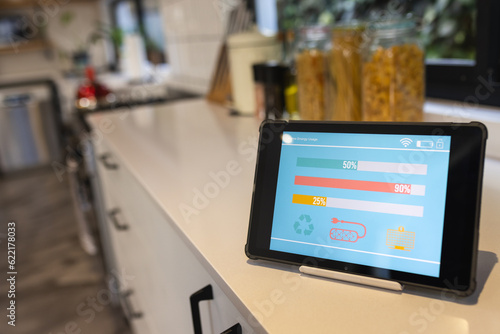 Tablet with smart home interface on white worktop in kitchen