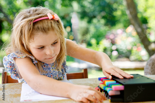 Cute Little Preschooler Child Drawing at Home. Happy Girl with Colorful Felt Pens. Hobby for Children. Leisure Activity for Small Kids.