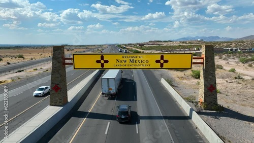 New Mexico welcome sign above highway. Aerial dolly forward towards establishing sign of NM. photo