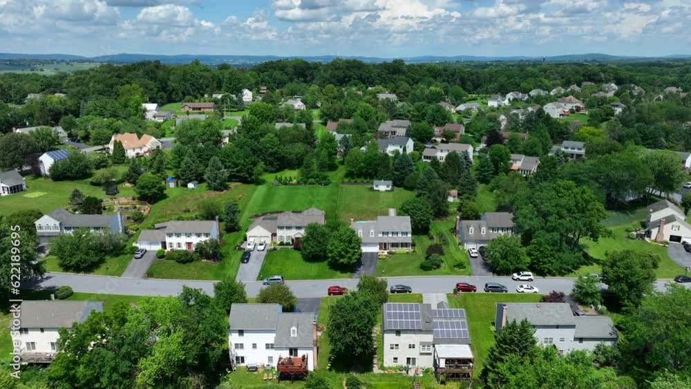 Aerial tilt up shot of beautiful American neighborhood with solar panels on roof in natural area with green trees - Panorama wide shot Aerial tilt up shot of beautiful American neighborhood with solar panels on roof in natural area with green trees - Panorama wide shot