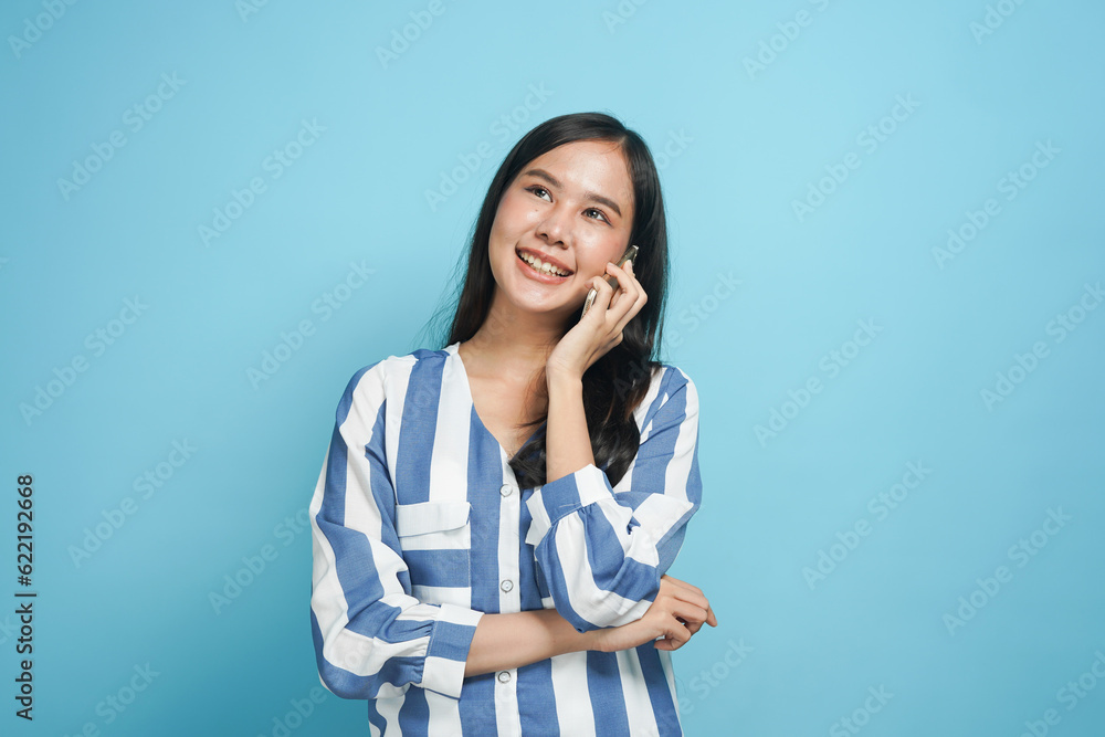 Happy Asian woman talking on smartphone with smile isolated on background Happy Asian woman talking on smartphone with smile isolated on background