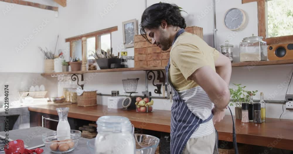 Caucasian man wearing apron in kitchen, slow motion Caucasian man wearing apron in kitchen, slow motion