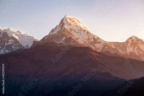 Machhapuchhre Peak, the sunrise area of annapurna base camp, Nepal, is a very beautiful peak of the Himalayas. snow capped peaks photo from a distance The red-orange morning sun shines brightly.