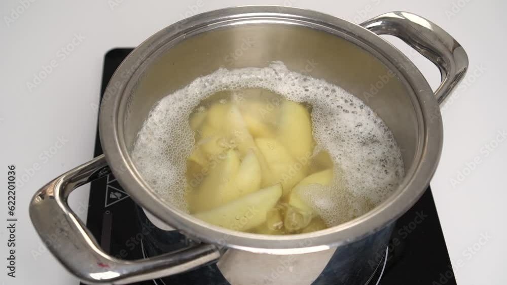 Pot with sliced potatoes cooked on stove top. Water is simmering slightly. Process and recipe for rustic or Idaho potatoes. Boil for 3 minutes. Step by step. Step 4. Pot with sliced potatoes cooked on stove top. Water is simmering slightly. Process and recipe for rustic or Idaho potatoes. Boil for 3 minutes. Step by step. Step 4.