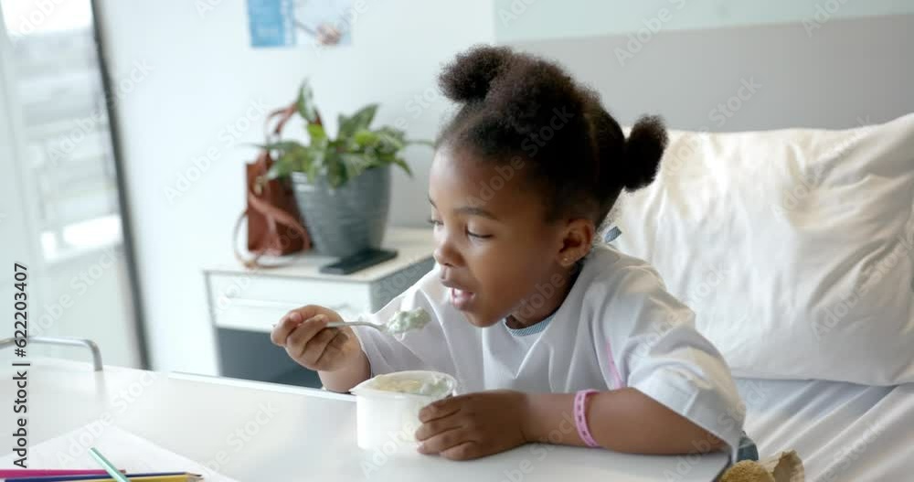 African american girl eating lunch in hospital bed, slow motion African american girl eating lunch in hospital bed, slow motion