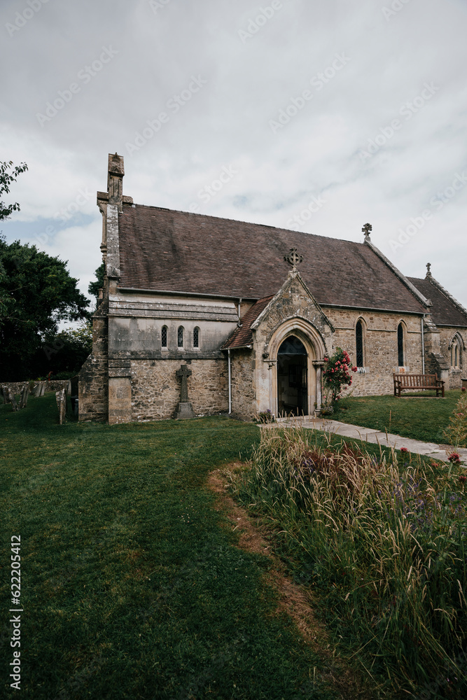 A old small size church and garden with some trees and cloudy sky A old small size church and garden with some trees and cloudy sky