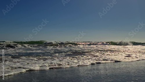 Low angle ground level pov of waves crashing on sea shore photo