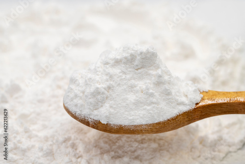 Wheat starch on wooden spoon. spice or seasoning as background. close-up Wheat starch photo