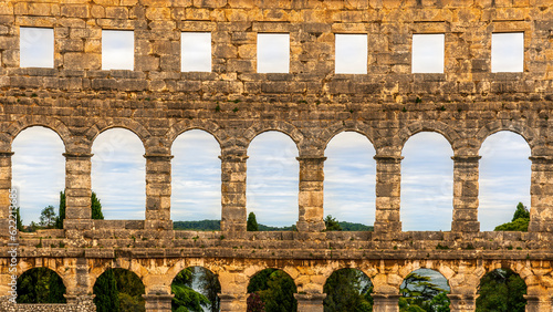 ancient wall with arches and windows of historical building, ancient architecture outdoor , roman arena in Pula