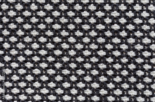 Close-up of black and white "goose foot" suiting fabric. Textile background from interweaving of natural woolen and synthetic threads. Basis for sewing fashionable wrinkle-resistant office clothes.