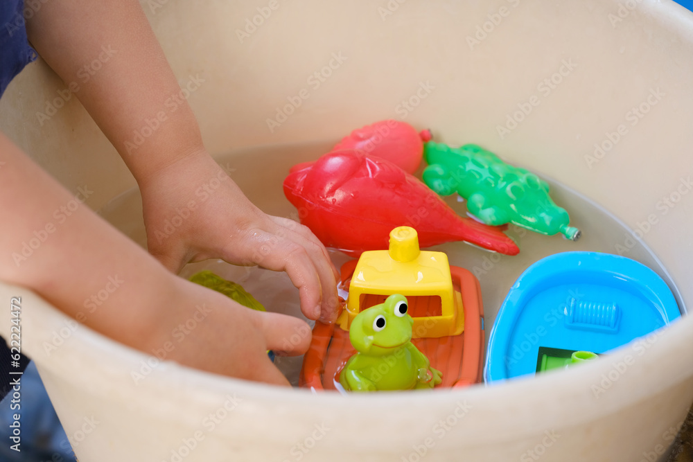 Φωτογραφία happy child 4 years old plays with rubber yellow duck for swimming, toys colored