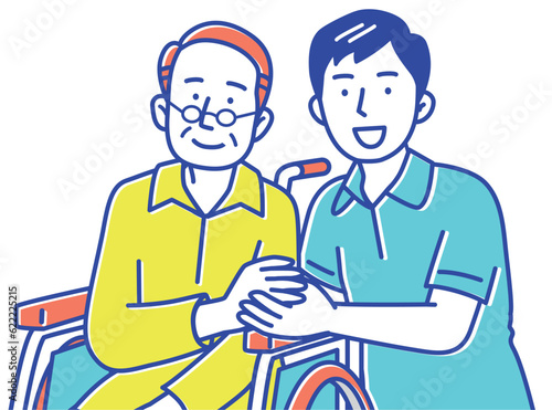 手を取り合う若い男性の介護士と車いすのシニア男性