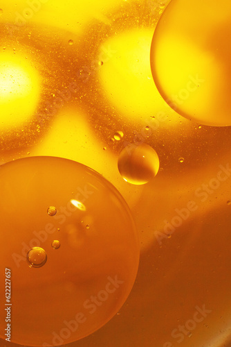 Gold Oil bubbles close up. circles of orange water macro. abstract shiny yellow background