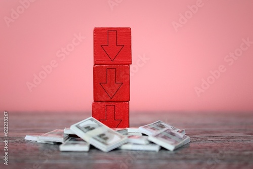 Red downward arrows on top of money. Bankruptcy, business loss, underpaid concept photo