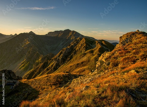 Sunrise from the ridge of the Western Tatras, Rohace with a view of the Salatin mountain with grass illuminated by the rising sun, camping and bivouac in nature. Tatras, tourist theme, tourist trail.
