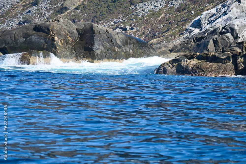 norway on the fjord, spray on rocks. Water splashes on the stones. Coastal landscape