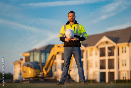Builder man at building site. Construction manager in helmet. Male construction engineer. Architect at a construction site. Handyman builder in hardhat. Building concept. Builder foreman.