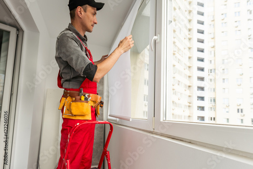 Construction worker installing new window in house