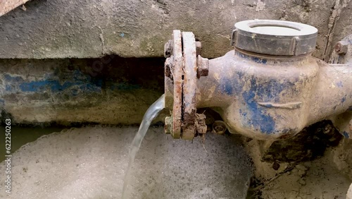 Liquid waste mixed with chemicals coming out from the water meter pipe. Pouring water produce foam. Chemical waste water from industrial process. Wastewater Treatment Procedure (WWTP) photo