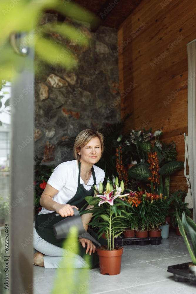 Small business entrepreneur owner,happy woman sitting with flowers at florist shop service job. Portrait of caucasian girl successful owner environment, side view