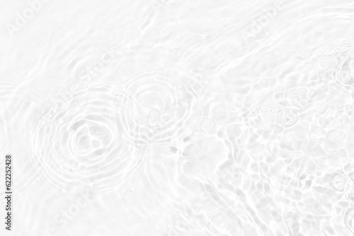 White water with ripples on the surface. Defocus blurred transparent white colored clear calm water surface texture with splashes and bubbles. Water waves with shining pattern texture background.