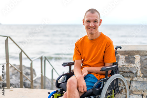 Portrait of a disabled person in a wheelchair on the beach on summer vacation