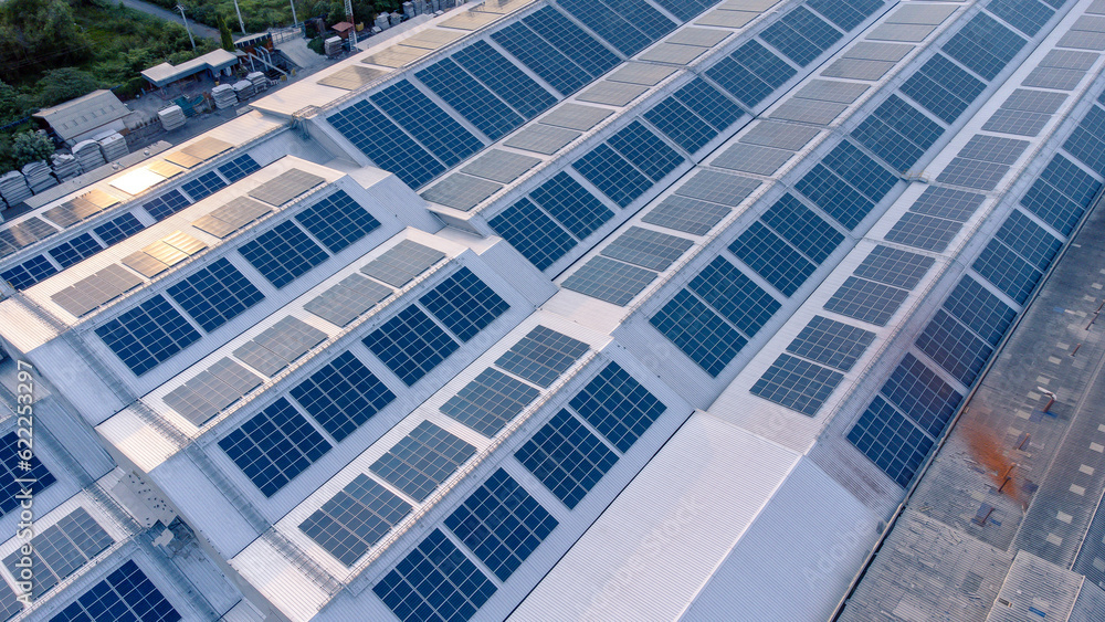 Aerial view of solar roof of the factory in eco environment. Solar Cells panel reflection with the sun and turn to blue color in industrial area. Concept of energy recycle.