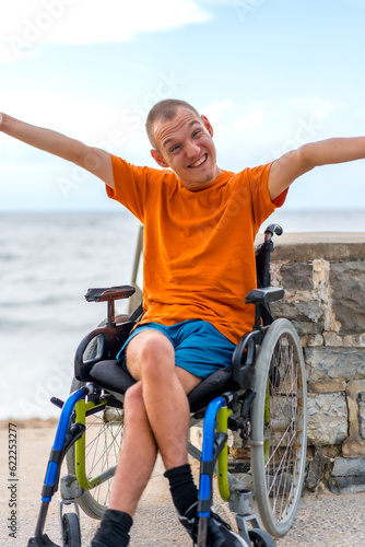 Portrait of pretty cheerful disabled person in wheelchair at the beach in summer vacation
