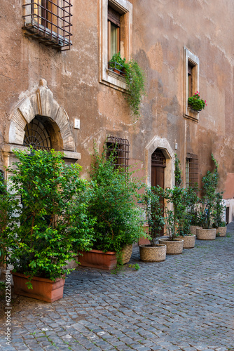 Old historic building in Rome with flowers and cobblestone street
