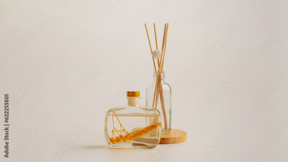 Reed diffuser bottle on the podium. Incense sticks for the home on white