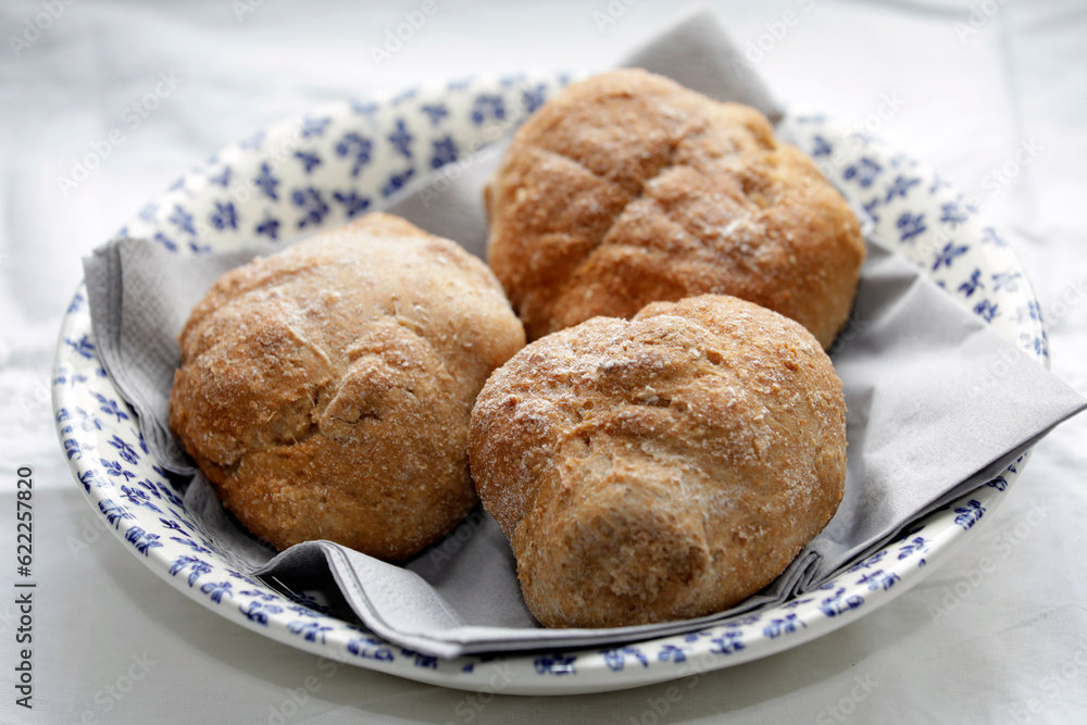 Homemade whole grain buns, spelled quark, healthy, low carb, diabetic fare, rolls, plate of white-blue flowers, close up. Homemade whole grain buns, spelled quark, healthy, low carb, diabetic fare, rolls, plate of white-blue flowers, close up.