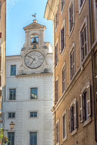 Bell on the top of the building with a wall clock