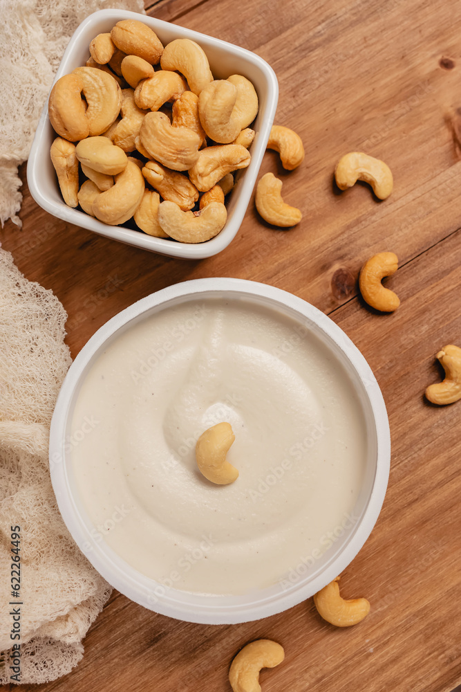 Cream cheese made of cashew on wooden table, healthy vegan alternative Cream cheese made of cashew on wooden table, healthy vegan alternative