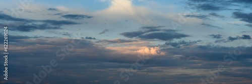 part of the blue sky is covered with thick clouds. widescreen panoramic view. format 15×5