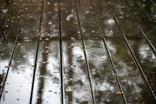 Rain drops on wet wooden floor of patio at raining day