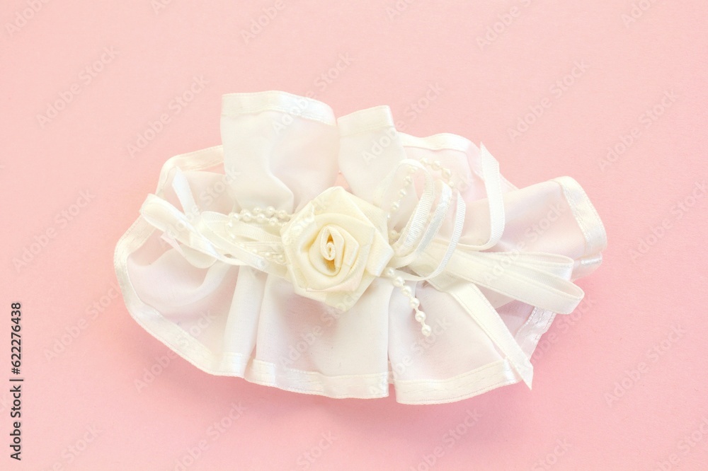 Handmade white wedding hair bow barrette on pink background. Elegant fashion design accessory for woman. Evening hairstyle silk ribbon. Hairpin for girl. Bridal clasp clips with jewellery details