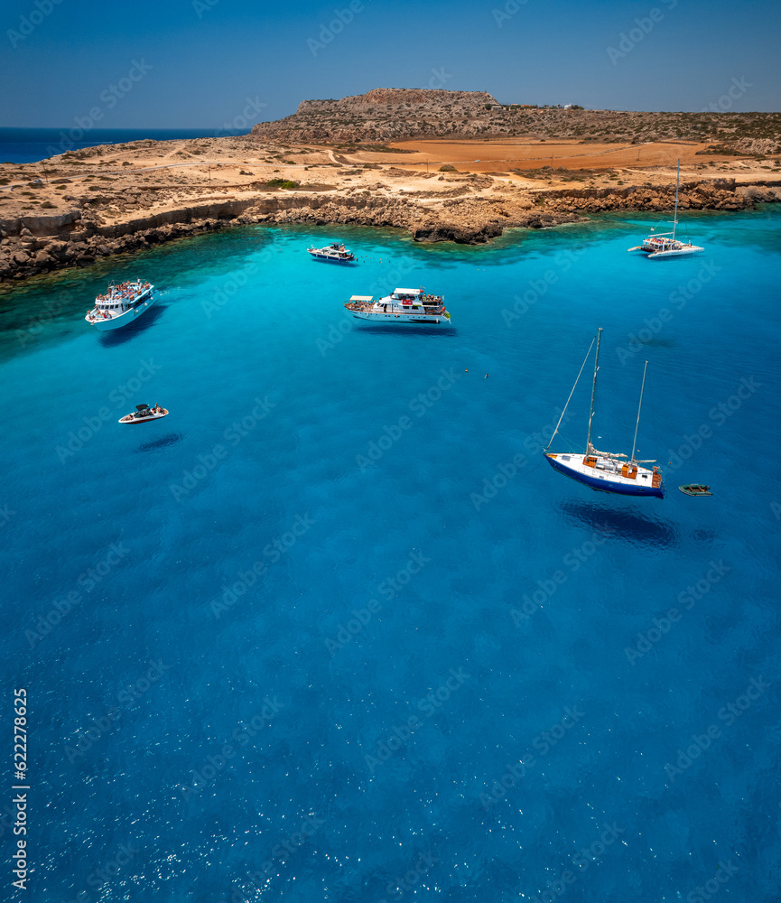 Aerial view of Cavo Greco's mesmerizing blue lagoon in Cyprus. Captured by a drone, the photo showcases the crystal-clear, transparent sea. With its vibrant blue hues and pristine waters