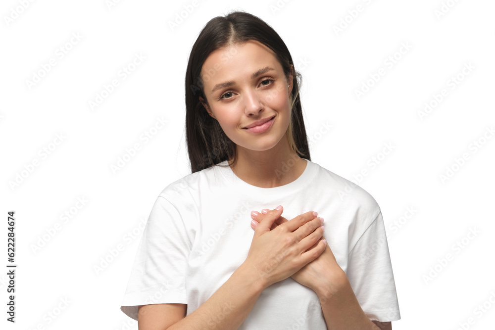 Portrait of smiling positive young woman keeps hands on chest, expresses sympathy. Kind hearted friendly nice female shows kindness Portrait of smiling positive young woman keeps hands on chest, expresses sympathy. Kind hearted friendly nice female shows kindness