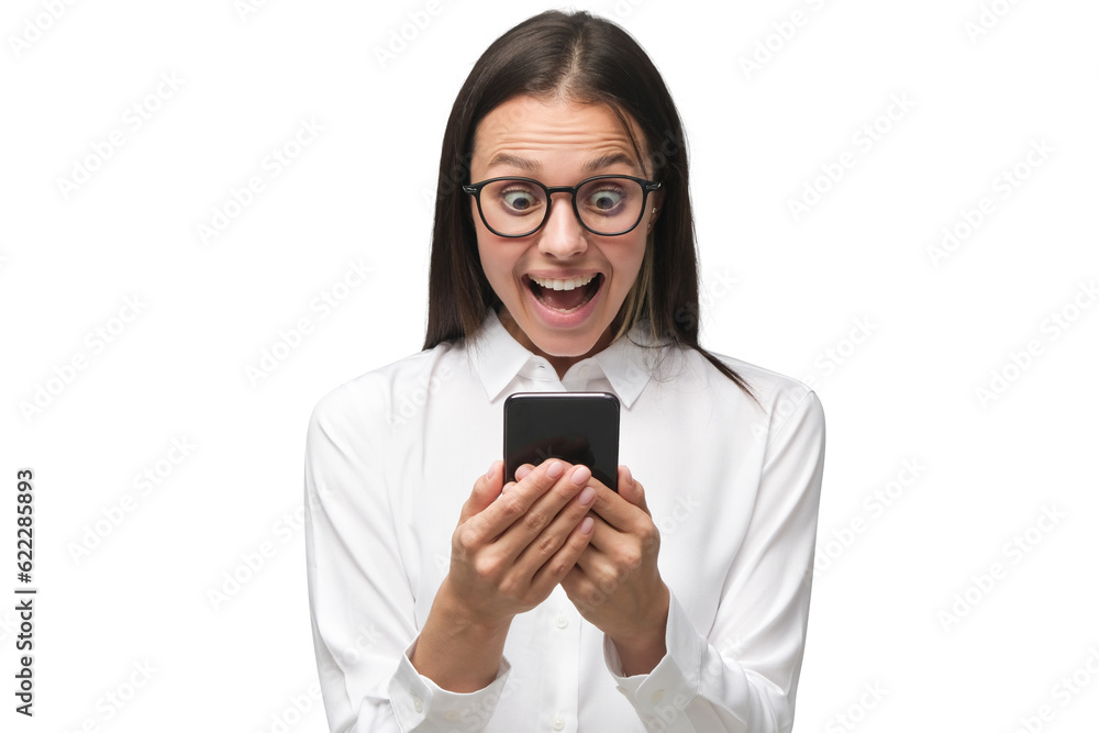 Surprised woman looking at smartphone screen with excited smile as if having won something Surprised woman looking at smartphone screen with excited smile as if having won something