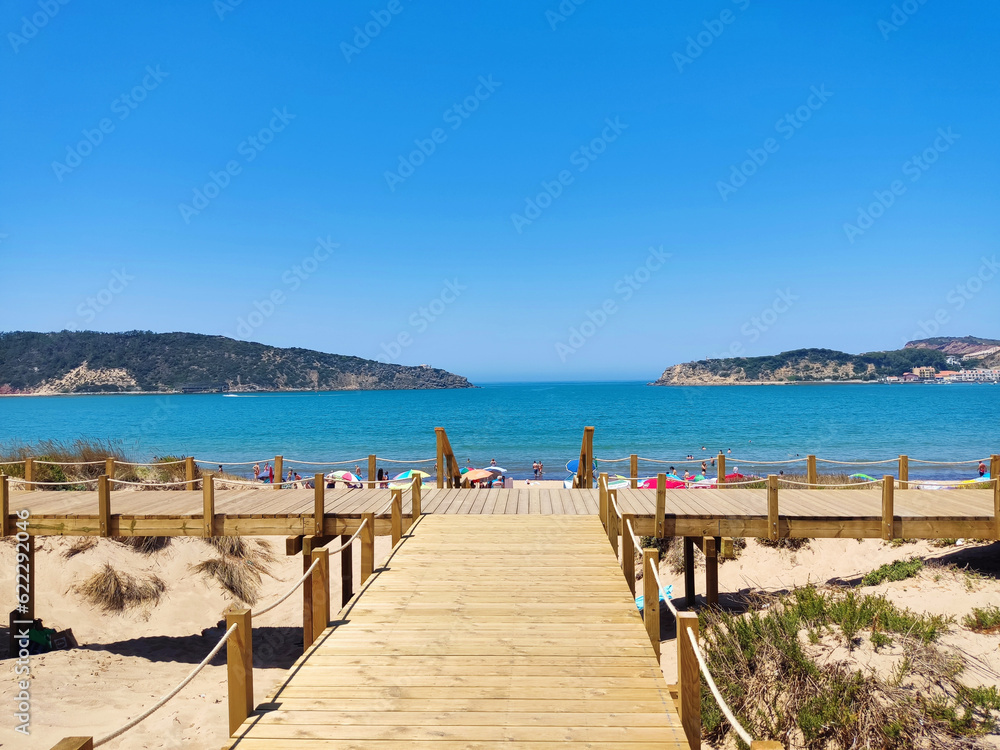 SAN MARTINHO, PORTUGAL – JULE 09, 2022: beautiful beach on the bay and wooden walking paths