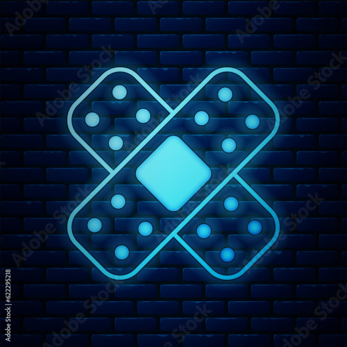 Glowing neon Crossed bandage plaster icon isolated on brick wall background. Medical plaster, adhesive bandage, flexible fabric bandage. Vector