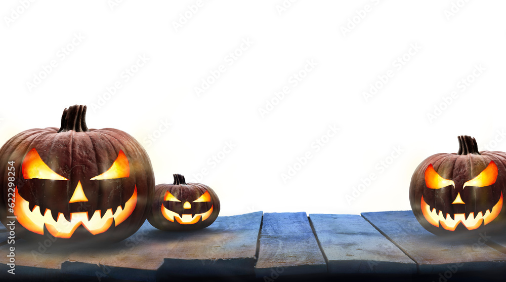 Three lit Jack-o-Lantern, halloween pumpkin lanterns on a wooden product display table with an isolated transparent background.